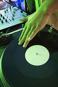 Close-up DJ's hand spinning vinyl record