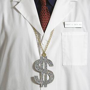 Close up of doctor wearing necklace with over-sized dollar sign.
