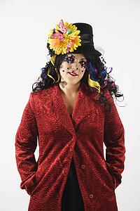 Woman in unique makeup and clothing standing against white background