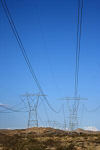 Electrical power lines in barren desert landscape