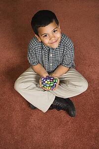Sitting on floor holding chocolate candy eggs