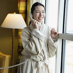 Woman in bathrobe talking on phone 