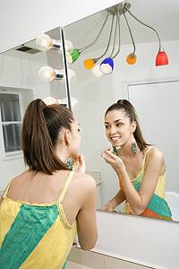 Looking in mirror applying makeup