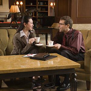 business people drinking coffee and conversing.