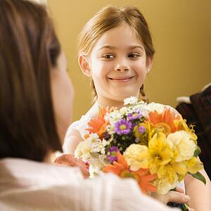 Girl giving mother flowers