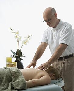 Massage therapist massaging back of woman 