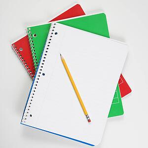 Pencil on top of three spiral bound notebooks