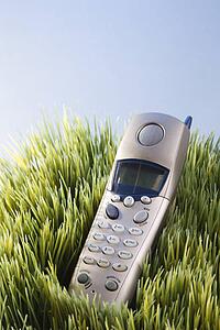 Studio shot of landline telephone placed in grass
