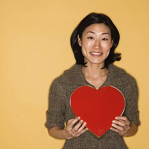 Woman holding red heart shaped box