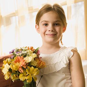 Girl smiling at viewer with bouquet of flowers