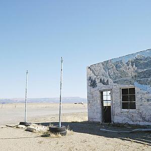 Building in barren desert landscape with winter scene mural painted on side