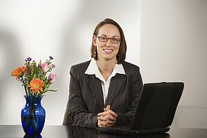 Businesswoman sitting at desk with a laptop