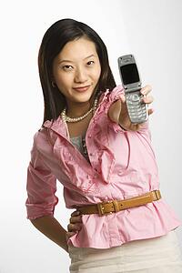 Female smiling and holding out cell phone