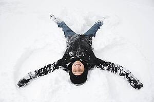 Woman making a snow angel 
