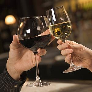 male and female hands toasting wine glasses