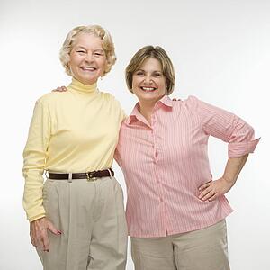 Two women smiling with arms around each other.