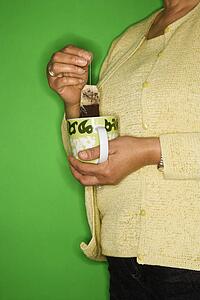 Female dipping tea bag in mug