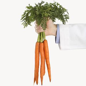 Caucasian mid adult male physician holding bunch of carrots.