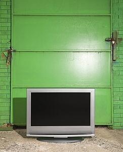 Flat panel television in front of green metal door