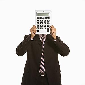 African American man holding oversized calculator over his face.