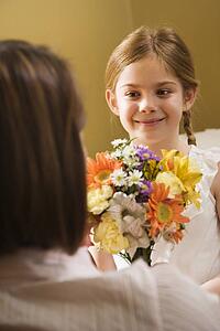 Girl giving mother flowers