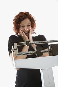 Pregnant woman surprised by her weight shown on scale