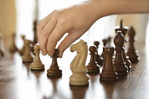 hand moving chess piece