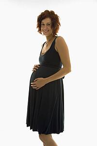 pregnant woman standing with hands on belly