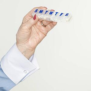 female hand holding pill box