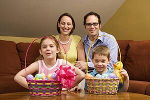 Caucasian family with Easter baskets looking at viewer. 