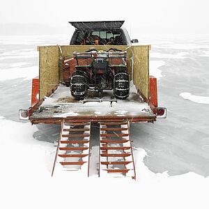 Trailer with ATV parked on frozen lake in Green Lake, Minnesota
