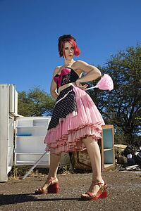 Young adult Caucasian female house cleaning in junkyard.