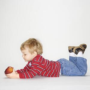 Studio portrait of boy holding apple against white background