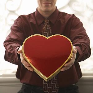 Man holding a heart shaped box of chocolates