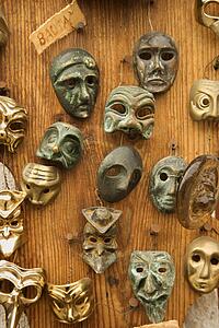 theatrical masks hanging on wooden wall