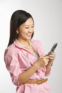 Portrait of mid-adult female smiling and text messaging on cell phone