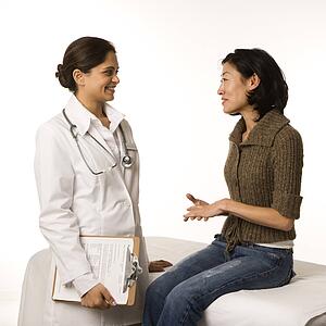 Indian woman doctor with Asian woman patient.