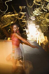 Woman on patio in New York City, New York at night with blurred lights