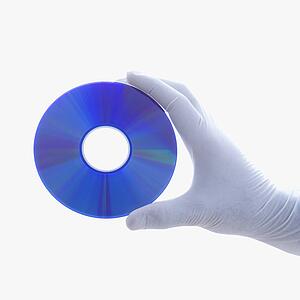 Hand in latex glove holding compact disc against white background
