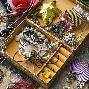 Above view of open jewelry box sitting on top of dresser.