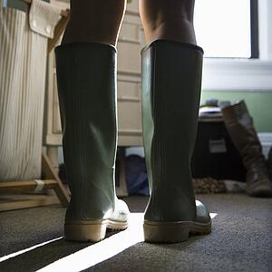 Woman's legs wearing green rubber boots