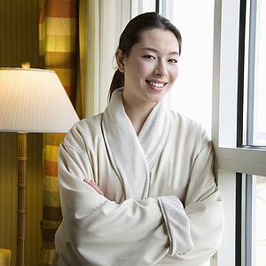 Woman in bathrobe smiling with arms crossed