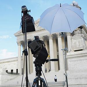 TV production set with camera and lighting equipment on tripods in front of Supreme Court building in Washington D. C.