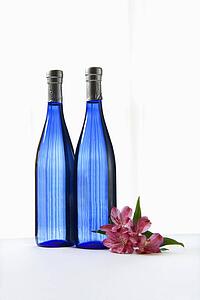 Two blue bottles with Astremeria flower