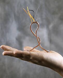 Male adolescent hand holding wire sculpture
