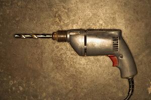 Electric drill resting on cement floor