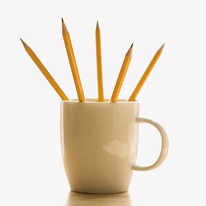 Five pencils in a coffee cup with pointed ends up