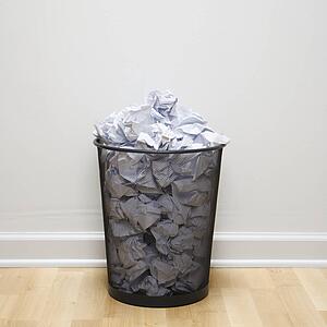 Wire mesh trash can filled with crumpled paper