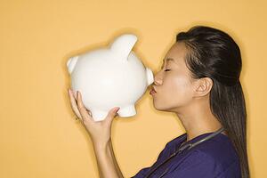 Doctor kissing piggy bank 
