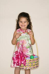 Girl holding Easter basket smiling and looking at viewer
